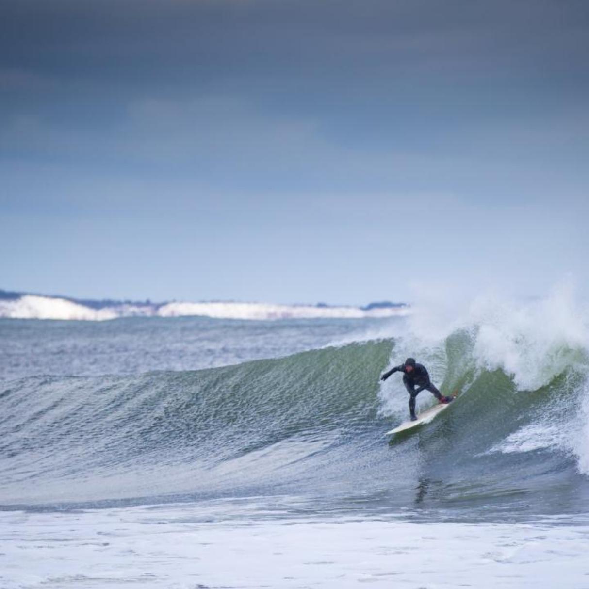 A surfer catches a wave at Lawrencetown beach in Nova Scotia