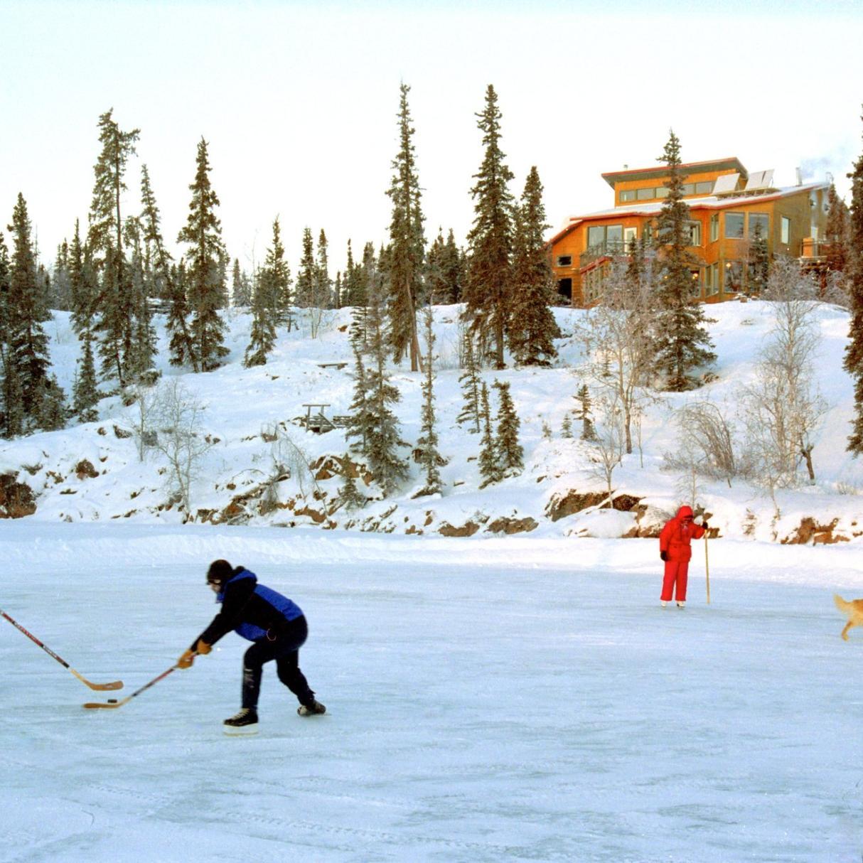 People playing lake hockey in front of Blackford Lake Lodge