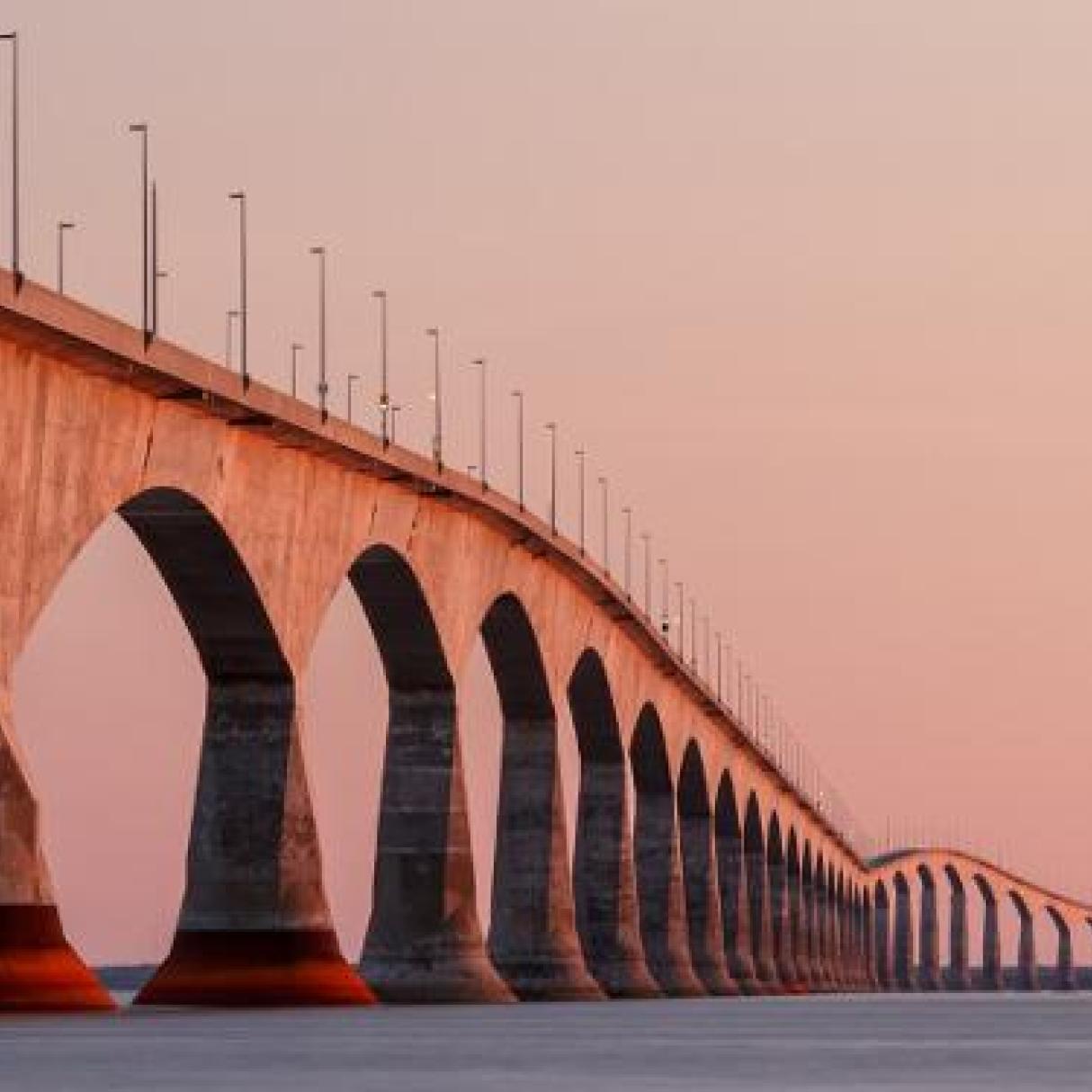 A long bridge looks pink at dusk