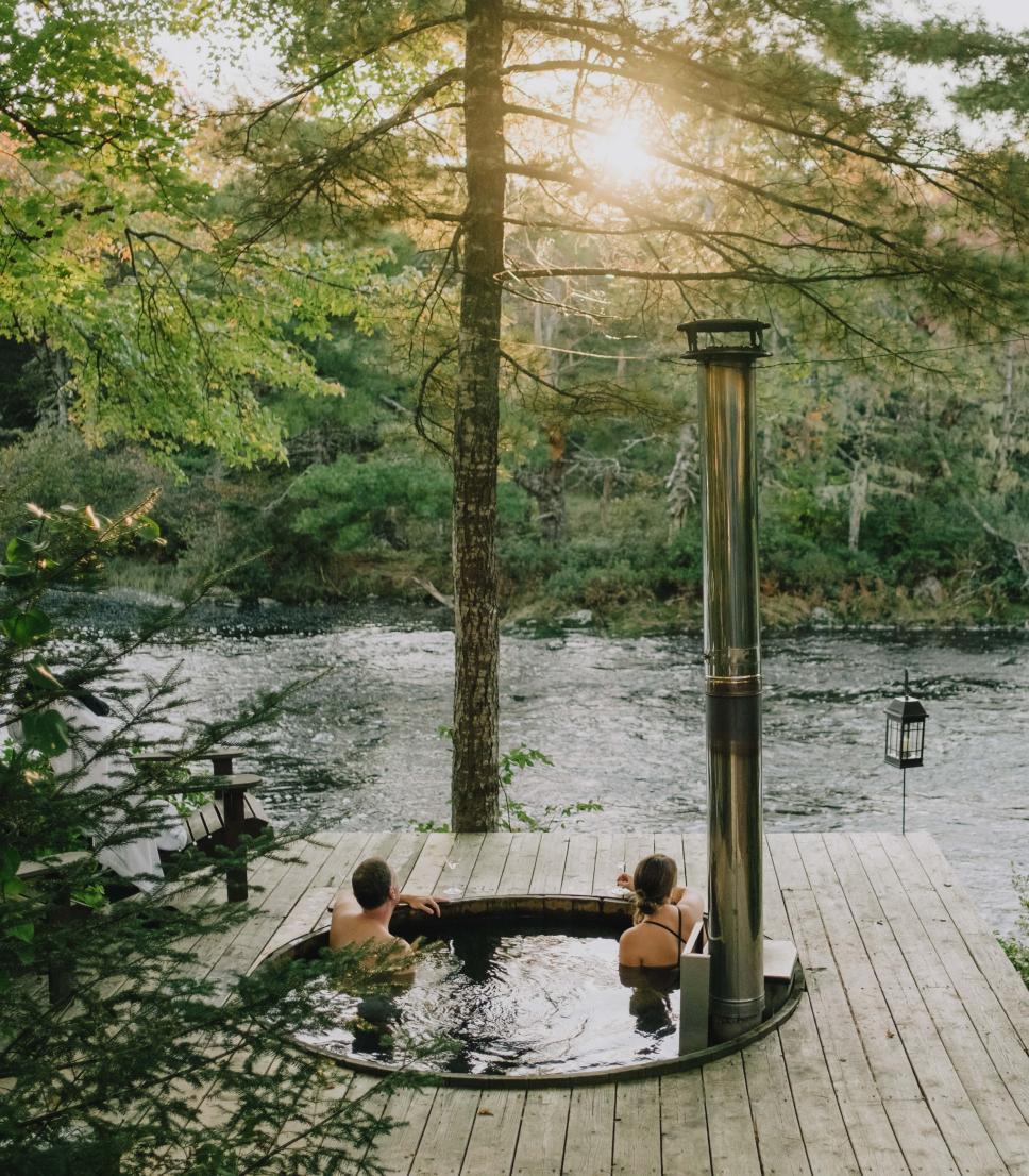 A couple enjoying a hot tub at Trout Point Lodge in Nova Scotia